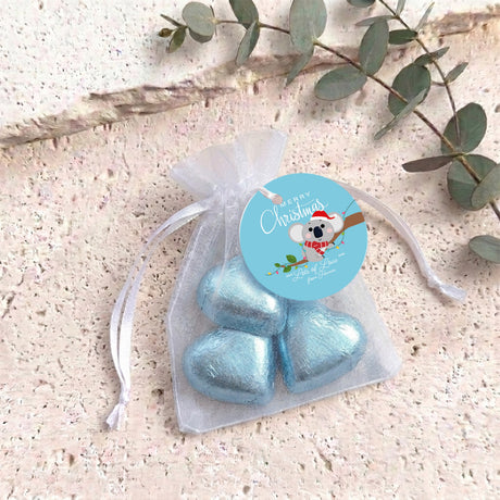 Light blue heart chocolates in sheer white organza drawstring gift bag with round label