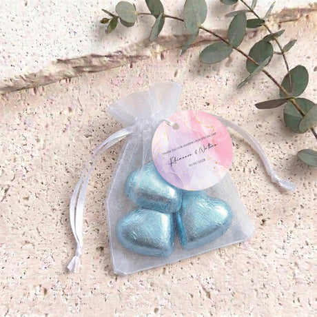 Personalised organza wedding favor bag with blue heart chocolates and round label