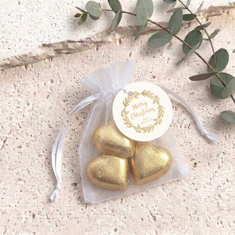 Gold heart chocolate gift bag with white round “Merry Christmas” label and organza ties