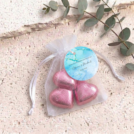 Organza drawstring gift bag with pink metallic heart chocolate and blue label