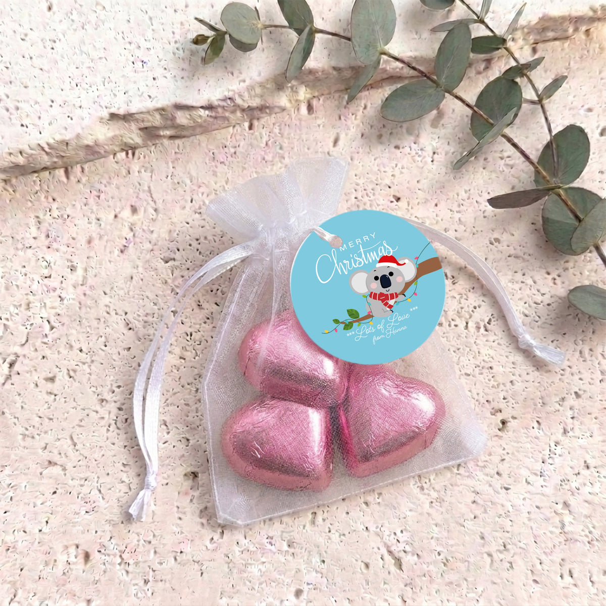 Pink heart chocolates in sheer white organza drawstring gift bag with round label