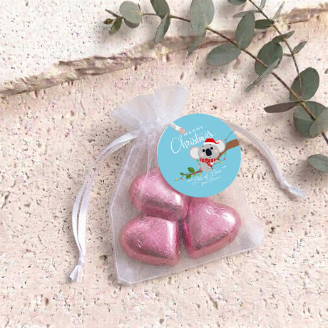 Pink heart chocolates in sheer white organza drawstring gift bag with round label