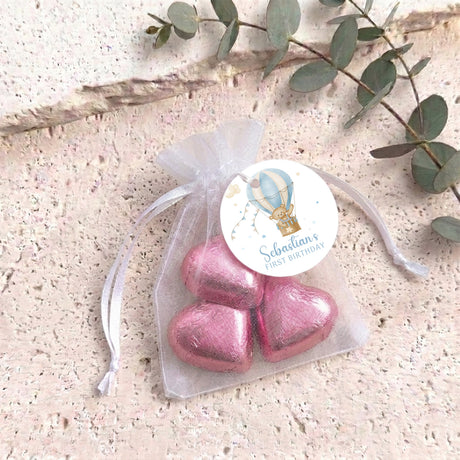 Rose-pink organza gift bag with metallic heart chocolates and a round personalized label