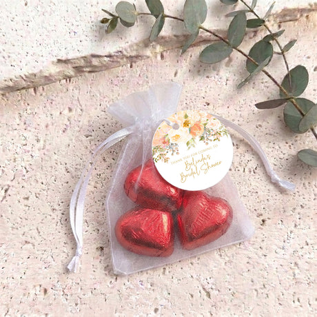 Bridal shower organza pouch with two red heart chocolates and floral round label