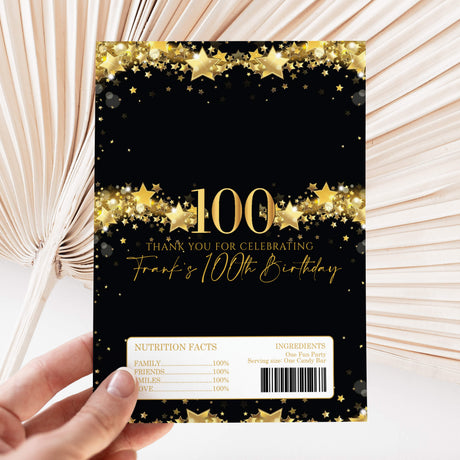 Chocolate wrapper sheet with black background, gold stars, “100” and birthday text