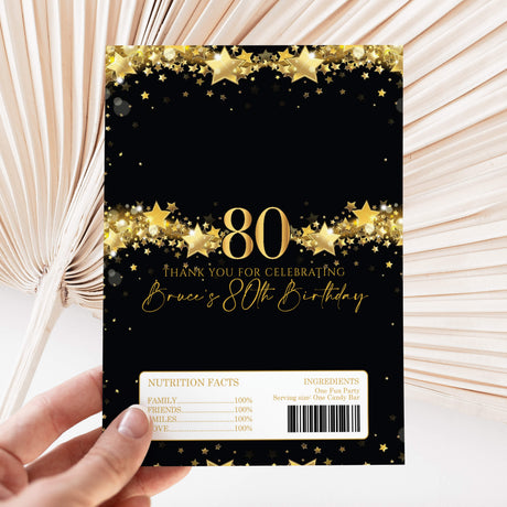 Black and gold 80th birthday DIY chocolate wrapper with star pattern, “80” and info label