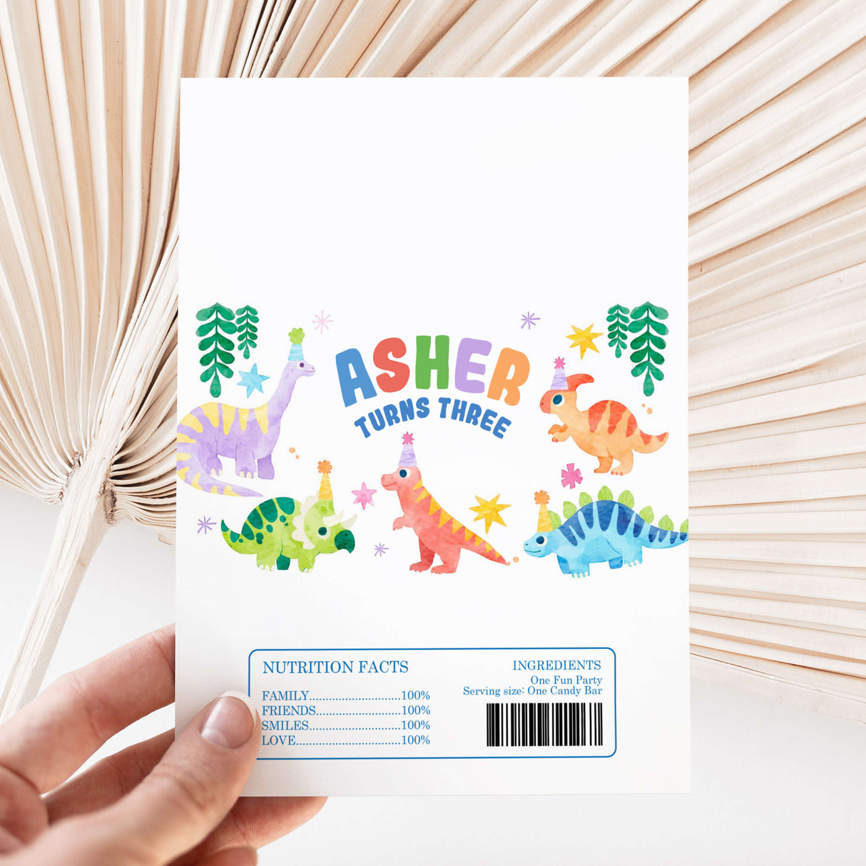 Dinosaur birthday chocolate wrapper with 'Asher turns three' text and cartoon dinos