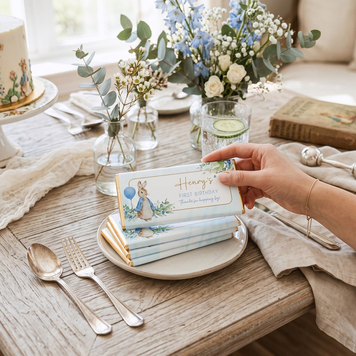 Favour Perfect personalised blue Peter Rabbit first birthday chocolate bar on a plate at a party table setting.