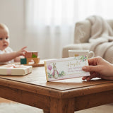 Favour Perfect personalised pink Peter Rabbit first birthday chocolate bar held in hand on a wooden table.